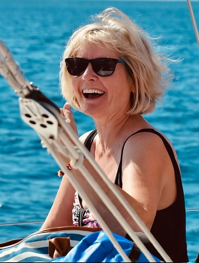 Smiling Lori Gradley on a boat enjoying freedom and positive mindset